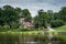 Old houses on the lakeside with reflection in cloudy summer day.