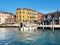 Old houses, moored boats and pedestrian bridge across Grand Canal in Venice, Italy.