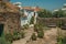 Old houses with whitewashed wall in an alley with flowers