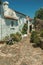 Old houses with whitewashed wall in an alley with flowers