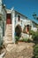 Old houses with whitewashed wall in an alley with flowers