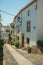 Old houses with whitewashed wall in an alley on slope