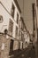 Old houses with worn plaster in alley on slope