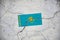 An old image of the flag of Kazakhstan on a wall with a crack