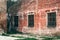 Old industrial metallic grid window with mullion and muntin on ruined factory building