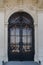 Old iron black door locked with ancient details. Aged closed front door at baroque architectural style. stone platband with