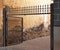 Old iron fence with open door and uncorked concrete wall. Close up of exterior metal enclosure. Locksmith, Architecture and
