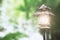 Old isolated lantern lighting at sunset with green leaf bokeh I