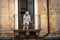 Old italian lady sweeping balcony. Catania, Sicily. Italy