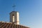 Old italian little church with metal Christian cross on the top against a sky - concept image with copy space