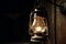 Old kerosene lamp hanging on a wooden wall in the dark Ai generative