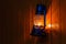 Old kerosene lantern hanging on the yellow wooden wall