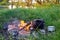 An old kettle with a cup stands on a fire in nature