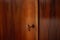 Old key sticks out in the keyhole of a brown lacquered chest door