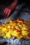 Old lady preparing baked potatoes with onions