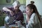 An old lady treats a little girl Breakfast, sitting at the table in his house.