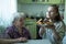 An old lady treats a little girl Breakfast, sitting at the table in his house.