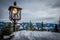 Old lantern stands on a railing and in the background are the snow-covered mountains