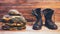 Old leather black men boots ankle boots, military uniforms and a flask of water on wooden background