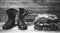 Old leather black mens boots ankle boots and a military uniform on wooden background front view closeup