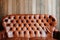 Old leather sofa on wooden background, void