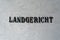 Old lettering Landgericht in front of a white textured wall