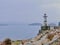 Old lighthouse on a calm rocky coast during a foggy morning