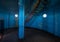 Old lighthouse on the inside. Red iron spiral stairs, round window and blue wall