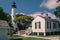 An old lighthouse and its surroundings in the town of Key West, Florida. White buildings on a summer day.