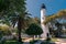 An old lighthouse and its surroundings in the town of Key West, Florida. White buildings on a summer day.