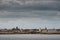 Old lighthouse on Mutton island, Galway cathedral in the background. View from the ocean. The Long Walk on the right. Cloudy sky