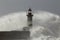 Old lighthouse surrounded by wave spray