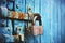 An old lock hangs on a rust-covered blue wooden gate. Closed