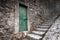 Old locked green door and stone stairway