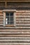 Old log house wood wall with window half closed with curtain