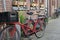 Old long Red vintage bike with two seats more behind the driver and big plastic box in front of him. Street view in Amsterdam,