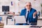 Old male employee in wheel-chair sitting in the office