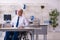 Old male employee in wheel-chair sitting in the office