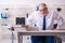 Old male employee in wheel-chair sitting in the office