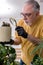 Old male gardener with plants indoors