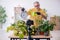 Old male gardener with plants indoors