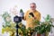 Old male gardener with plants indoors