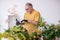 Old male gardener with plants indoors