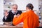 Old male judge meeting with young captive in courthouse