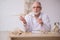 Old male paleontologist examining ancient animals at lab