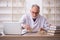 Old male paleontologist examining ancient animals at lab