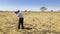 Old male photographer taking a photo savanna view