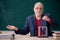 Old male teacher physicist sitting in the classroom