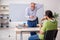 Old male teacher and young male student playing card in the clas