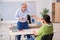 Old male teacher and young male student playing card in the clas